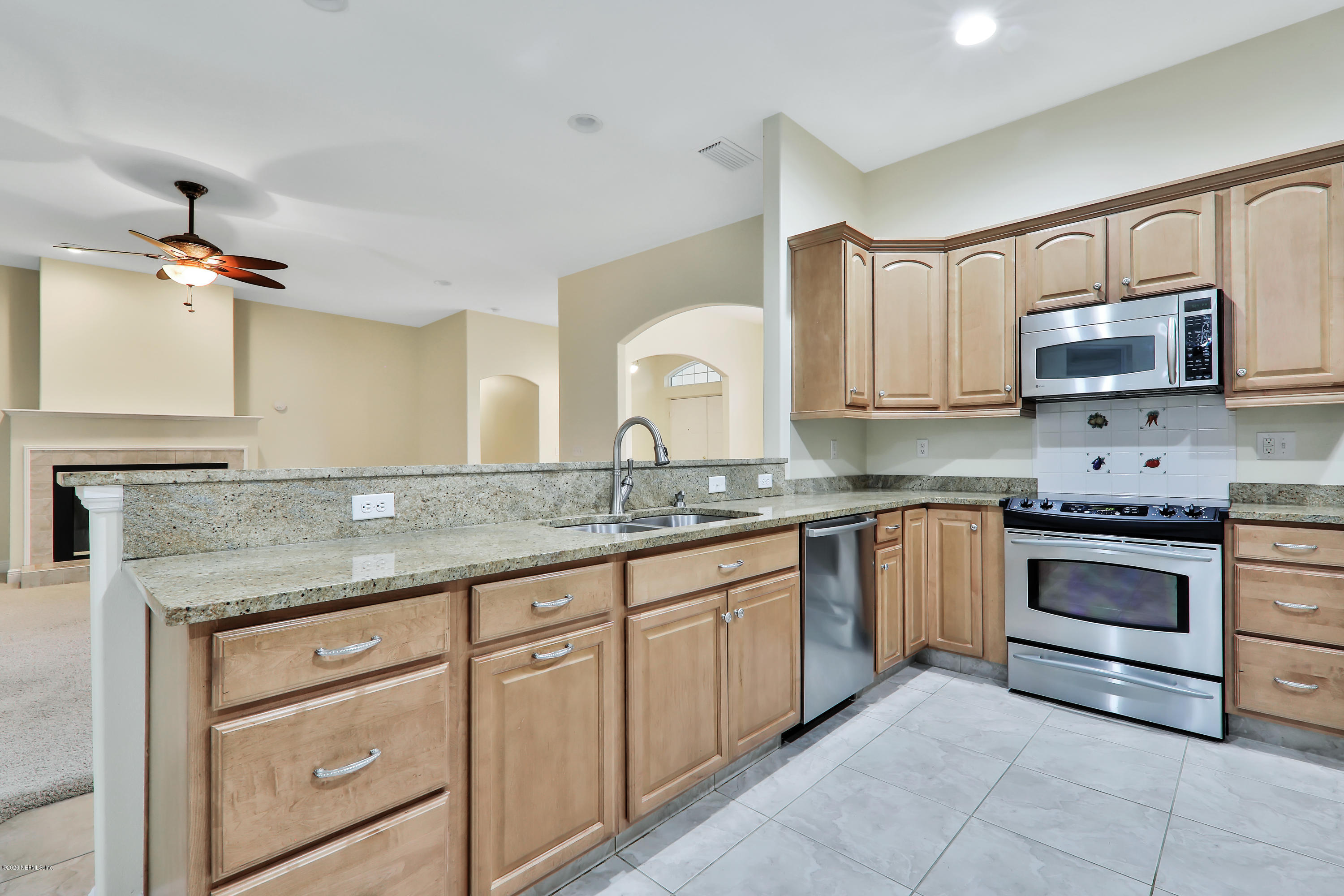 3289 Kings Road South St. Augustine, FL 32086 - Photo 29 of 41 a kitchen with kitchen island granite countertop white cabinets white stainless steel appliances with a sink and dishwasher
