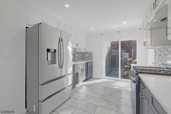 a kitchen with stainless steel appliances a refrigerator sink and cabinets