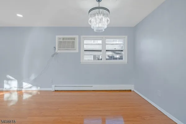 a view of empty room with wooden floor and window