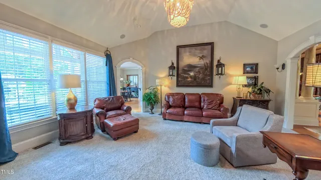 a living room with furniture a flat screen tv and a floor to ceiling window