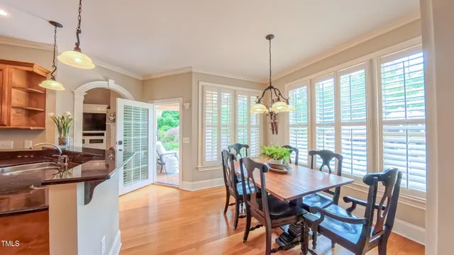 a living room with couches a flat screen tv and a table with wooden floor