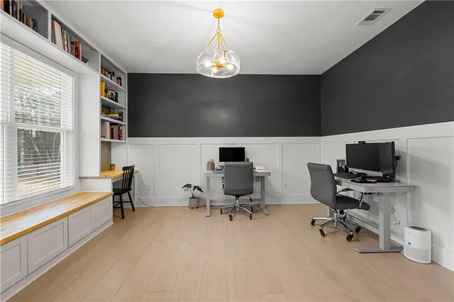 a kitchen with stainless steel appliances kitchen island granite countertop a refrigerator a stove a sink a dining table and chairs with wooden floor