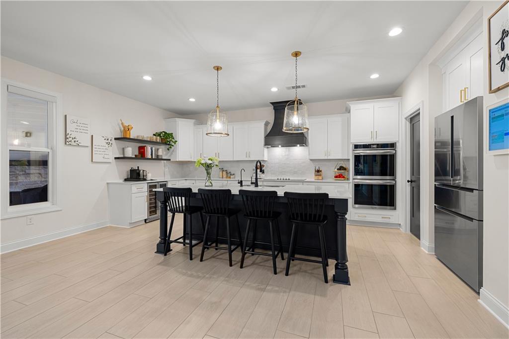 4895 Cool Springs Road Winston, GA 30187 - Photo 29 of 85 a kitchen with stainless steel appliances kitchen island granite countertop a refrigerator a stove a sink a dining table and chairs with wooden floor