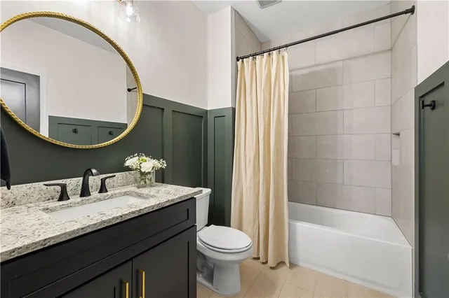 a bathroom with a granite countertop sink a toilet and shower