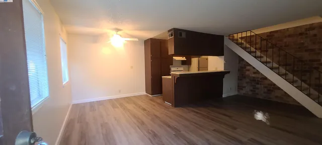 a view of a hallway with wooden floor and staircase
