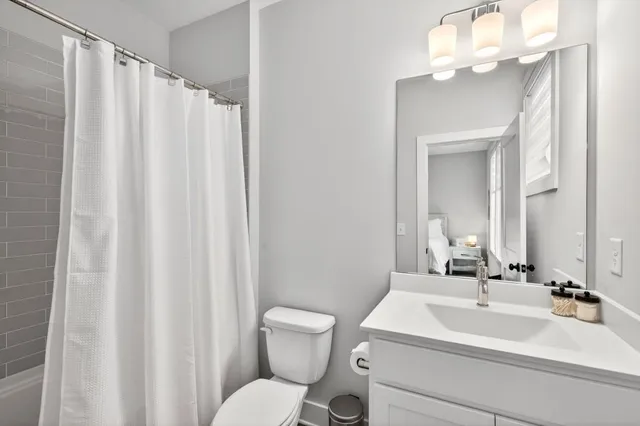 a bathroom with a sink a toilet and a mirror