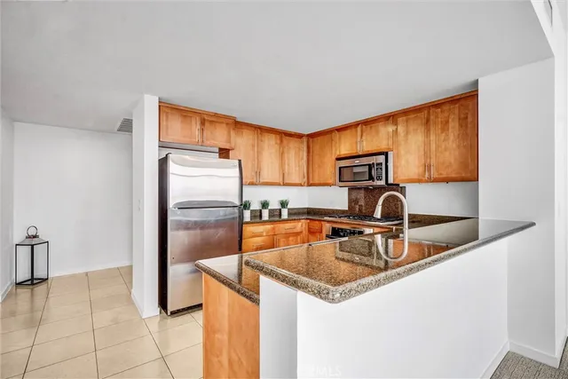 a kitchen with stainless steel appliances granite countertop a sink a stove and a refrigerator