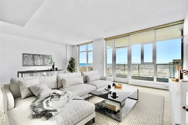 a living room with furniture and a large window with balcony view