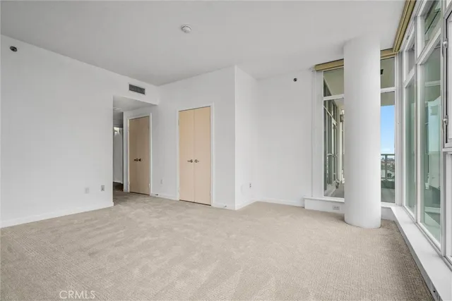 an empty room with windows and closet