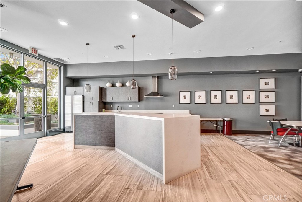 411 West Seaside Way, Unit 1804 Long Beach, CA 90802 - Photo 39 of 55 a large kitchen with stainless steel appliances granite countertop a refrigerator a sink dishwasher a stove and a dining table with wooden floor