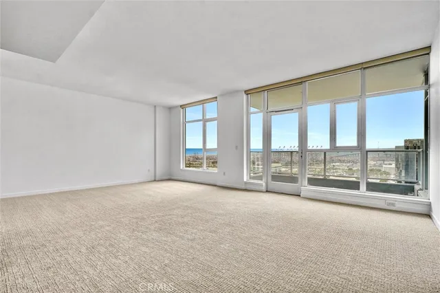 an empty room with floor to ceiling windows and city view