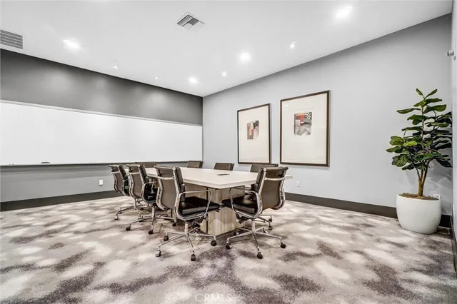 a view of a patio with couches table and chairs under an umbrella