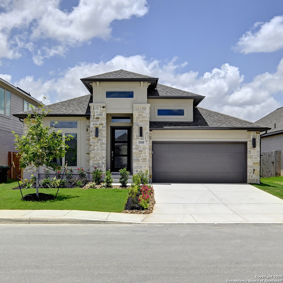 9719 Slick Fork San Antonio, TX 78254 - Photo 1 of 1 a front view of a house with a garden and garage
