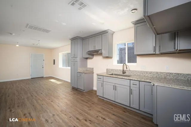 a kitchen with a sink cabinets stainless steel appliances and a counter top space