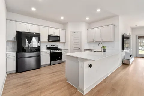 a kitchen with a sink stainless steel appliances and white cabinets