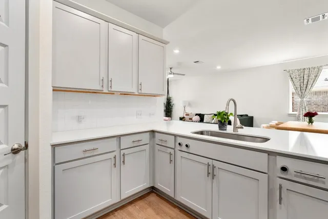 a kitchen with white cabinets and white appliances