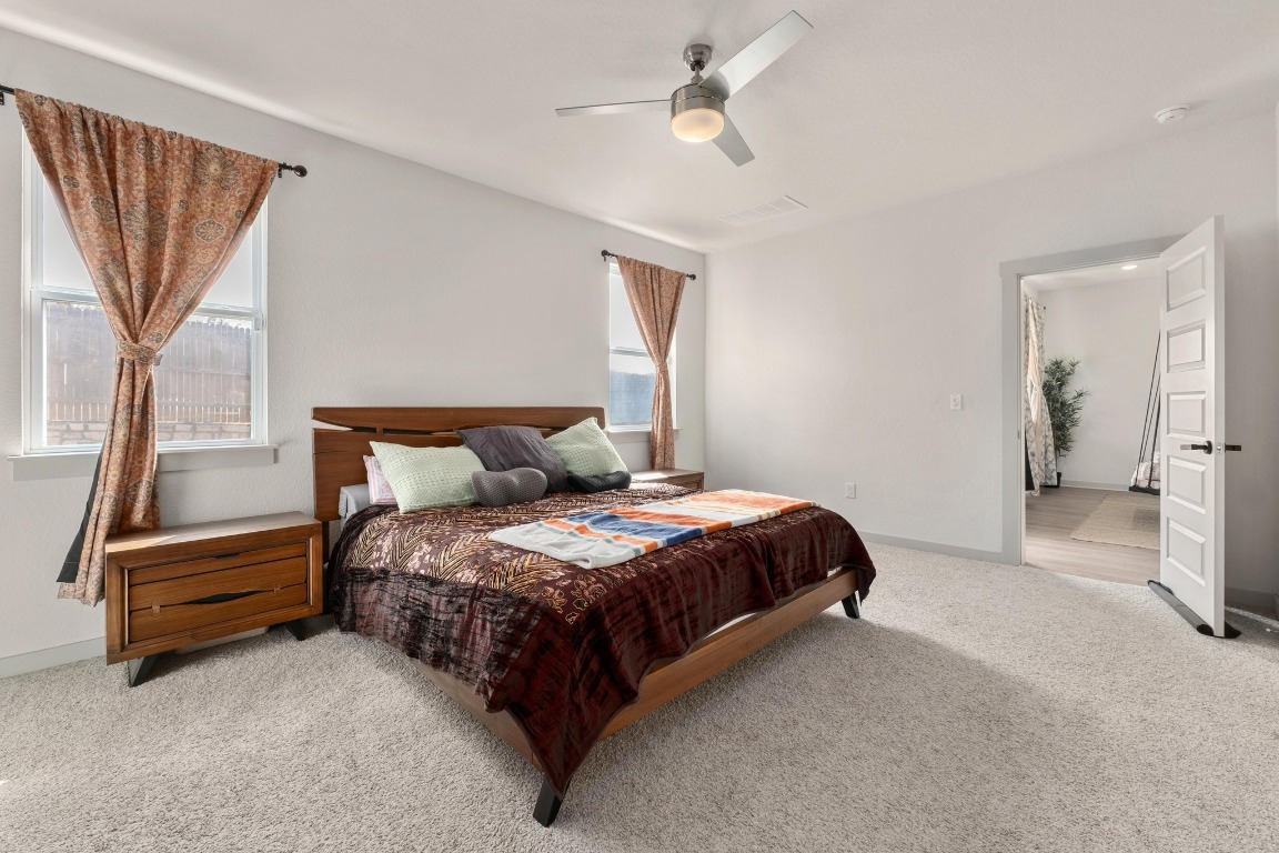 10509 Defender Trail Austin, TX 78754 - Photo 13 of 37 a spacious bedroom with a bed and a chandelier