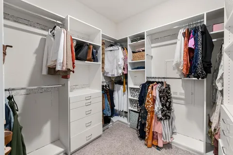 a view of walk in closet with clothes and shoes