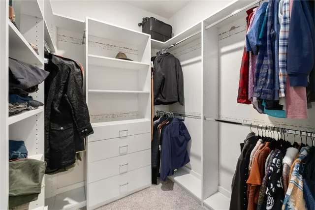 a view of walk in closet with clothes and shoes