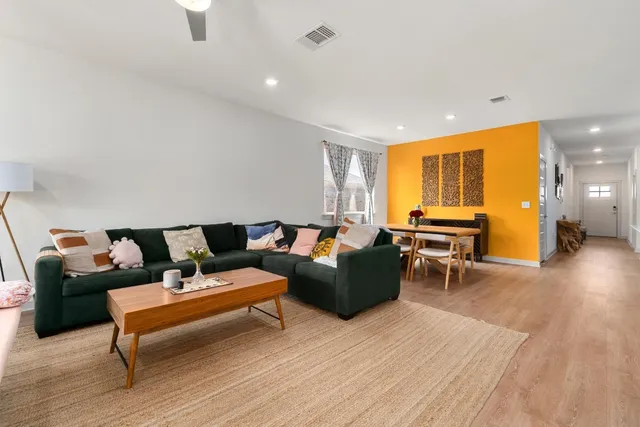 a living room with furniture and a wooden floor