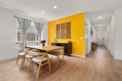 a dining room with wooden floor and furniture