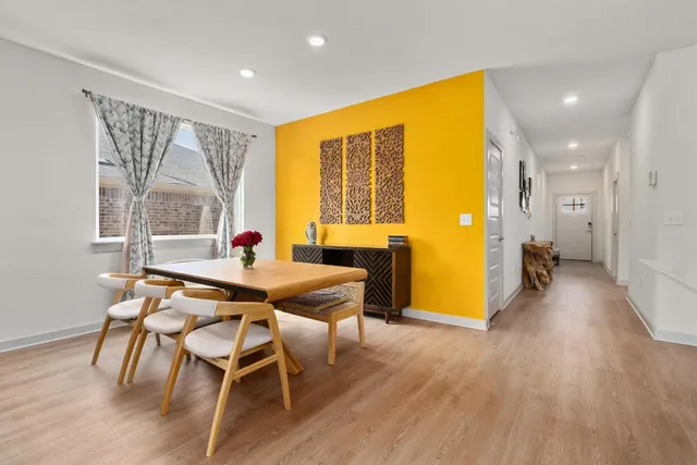 a dining room with wooden floor and furniture