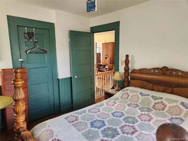a bedroom with a bed and a painting on the wall