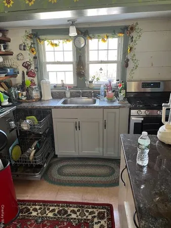 a kitchen with a stove a sink and a window