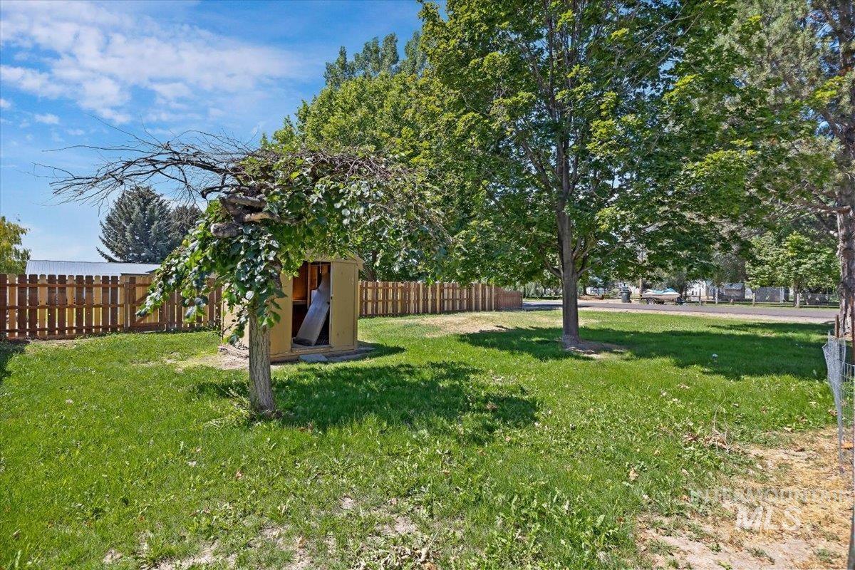 1940 Q Street Heyburn, ID 83336 - Photo 25 of 30 Expansive lawn area featuring mature trees and a wood storage shed