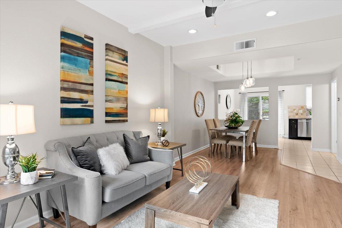 a living room with furniture a dining table and a potted plant