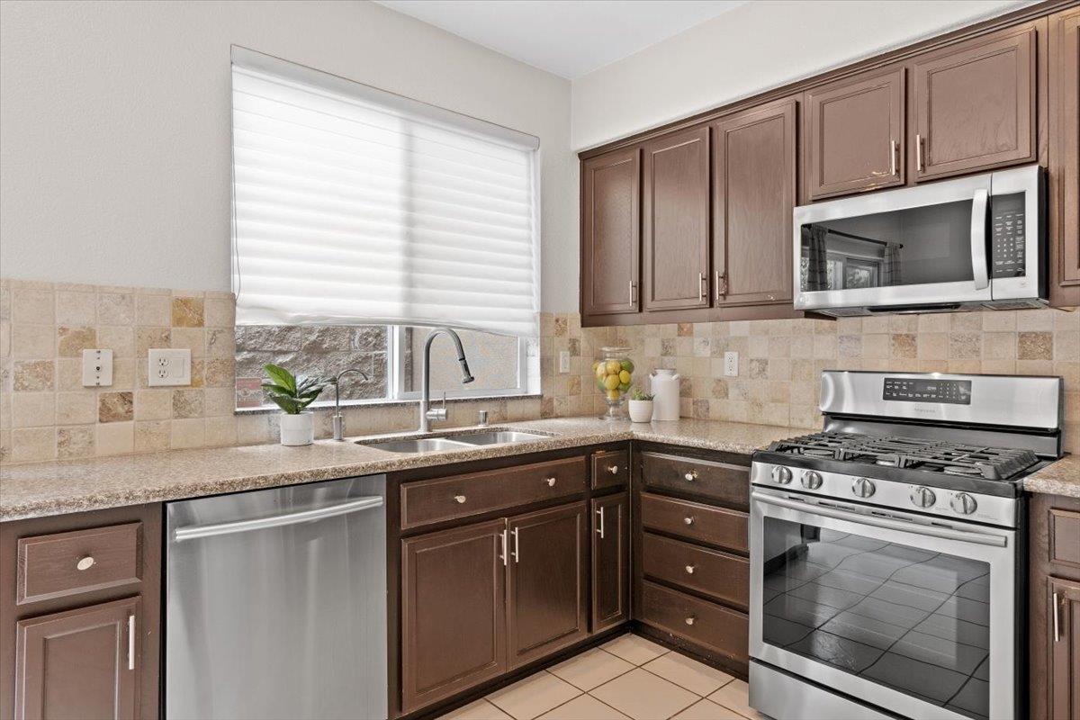 467 Whitechapel Avenue San Jose, CA 95136 - Photo 4 of 34 a kitchen with stainless steel appliances white cabinets granite counter tops and a window