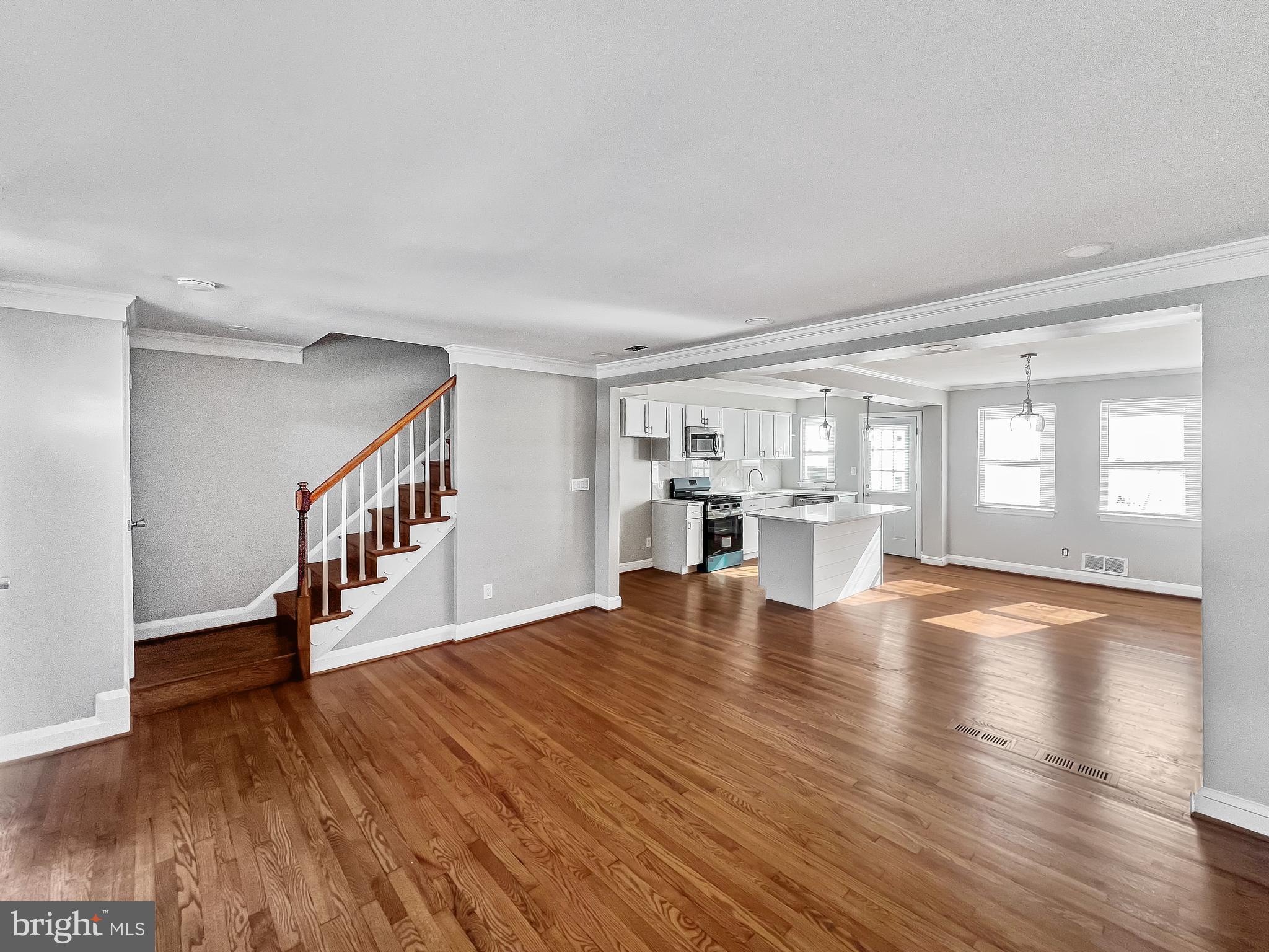 5755 Maplehill Road Baltimore, MD 21239 - Photo 2 of 9 a view of an empty room with wooden floor and a window