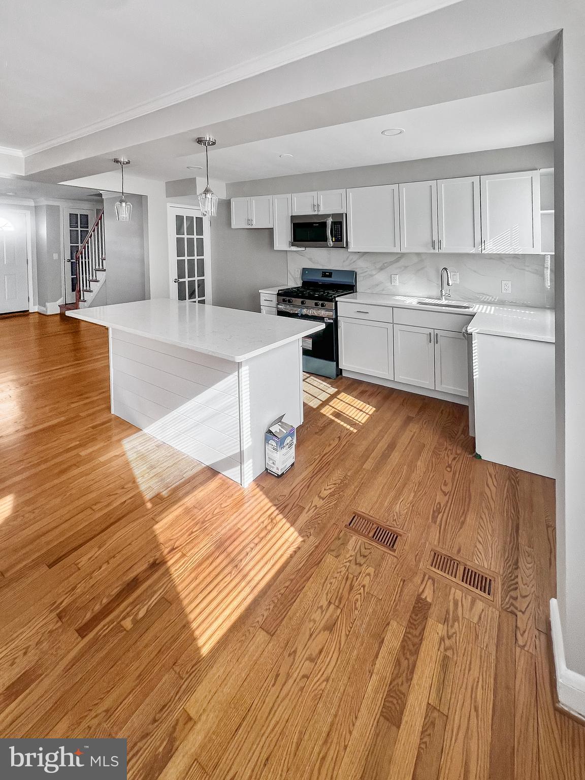 5755 Maplehill Road Baltimore, MD 21239 - Photo 3 of 9 a large kitchen with cabinets wooden floor and stainless steel appliances