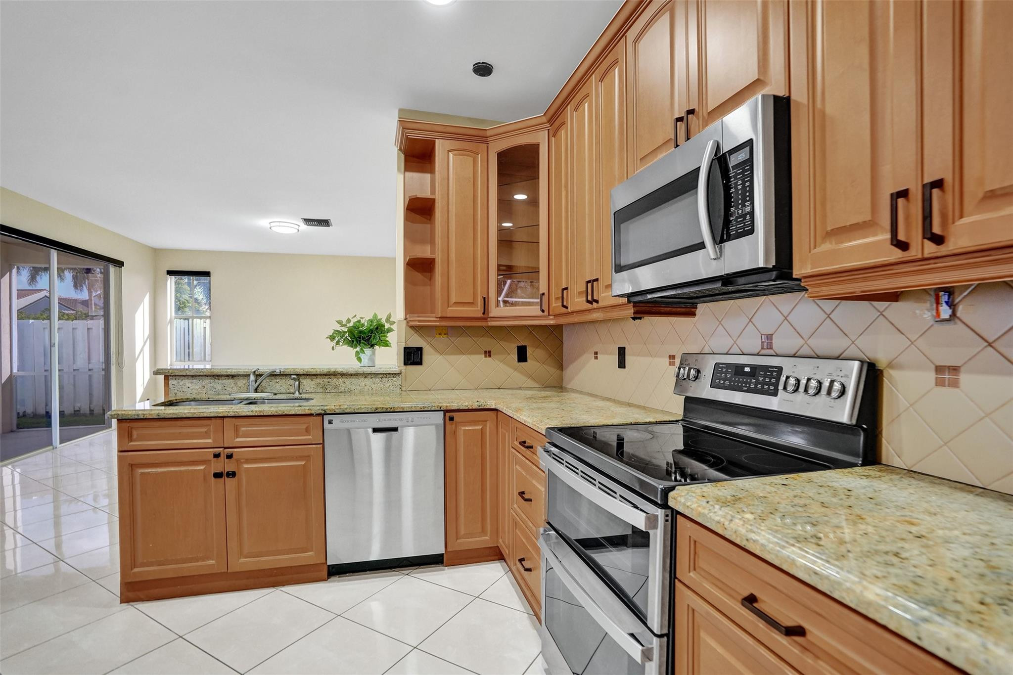 574 Slippery Rock Road Weston, FL 33327 - Photo 13 of 64 a kitchen with stainless steel appliances granite countertop a sink and a stove