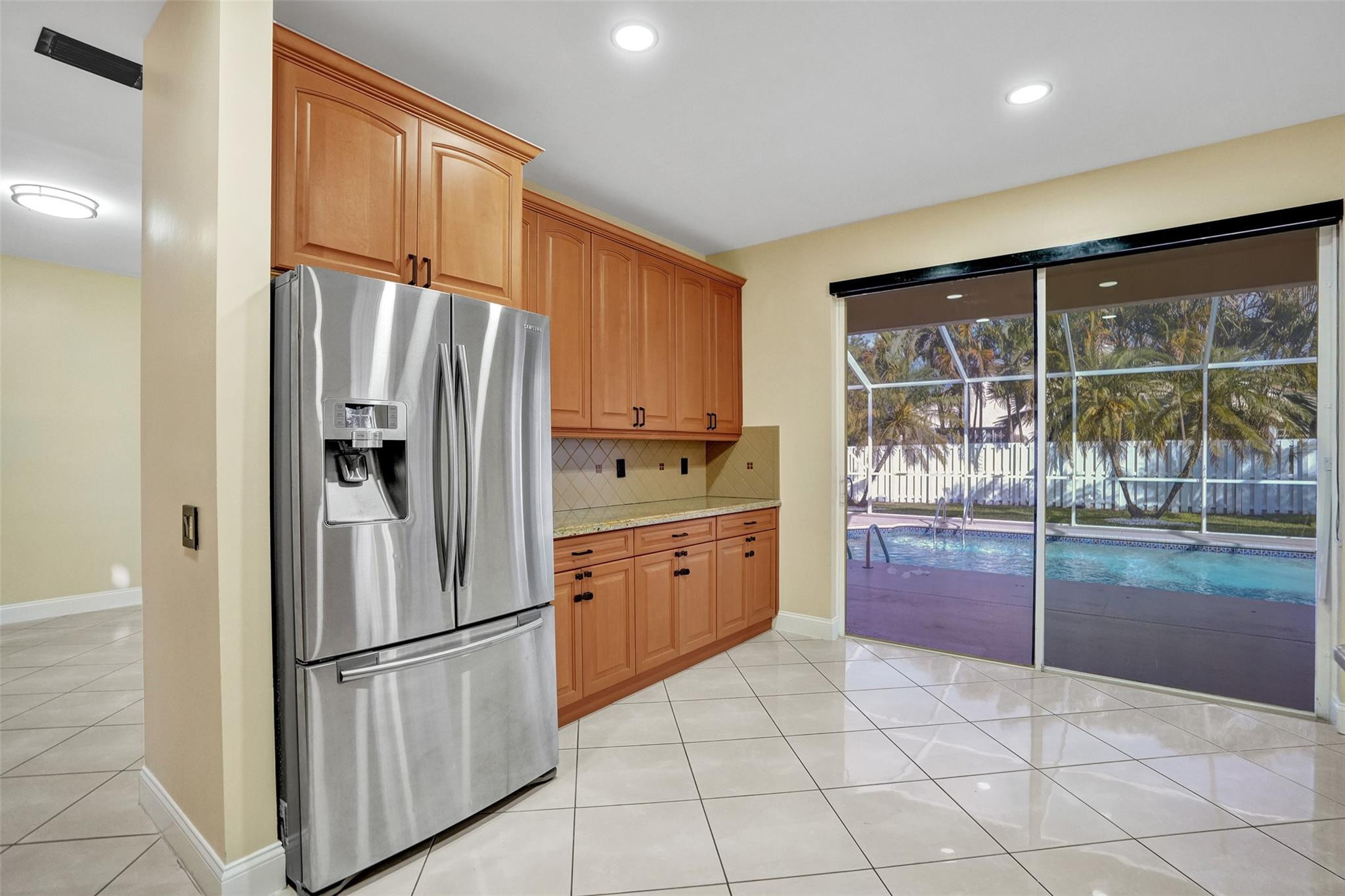 574 Slippery Rock Road Weston, FL 33327 - Photo 15 of 64 a kitchen with granite countertop a refrigerator and a sink