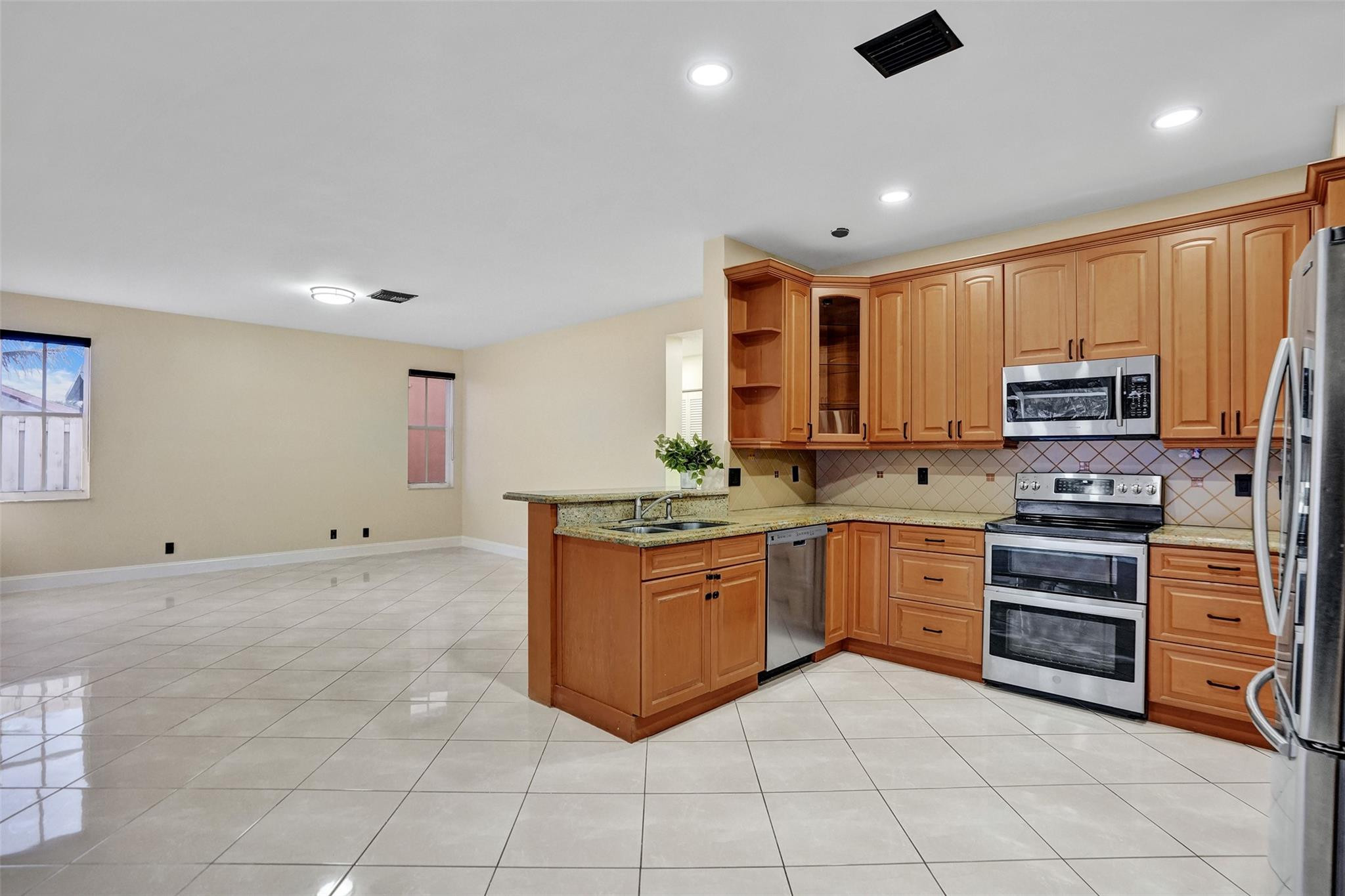 574 Slippery Rock Road Weston, FL 33327 - Photo 16 of 64 a kitchen with stainless steel appliances granite countertop a stove and a sink