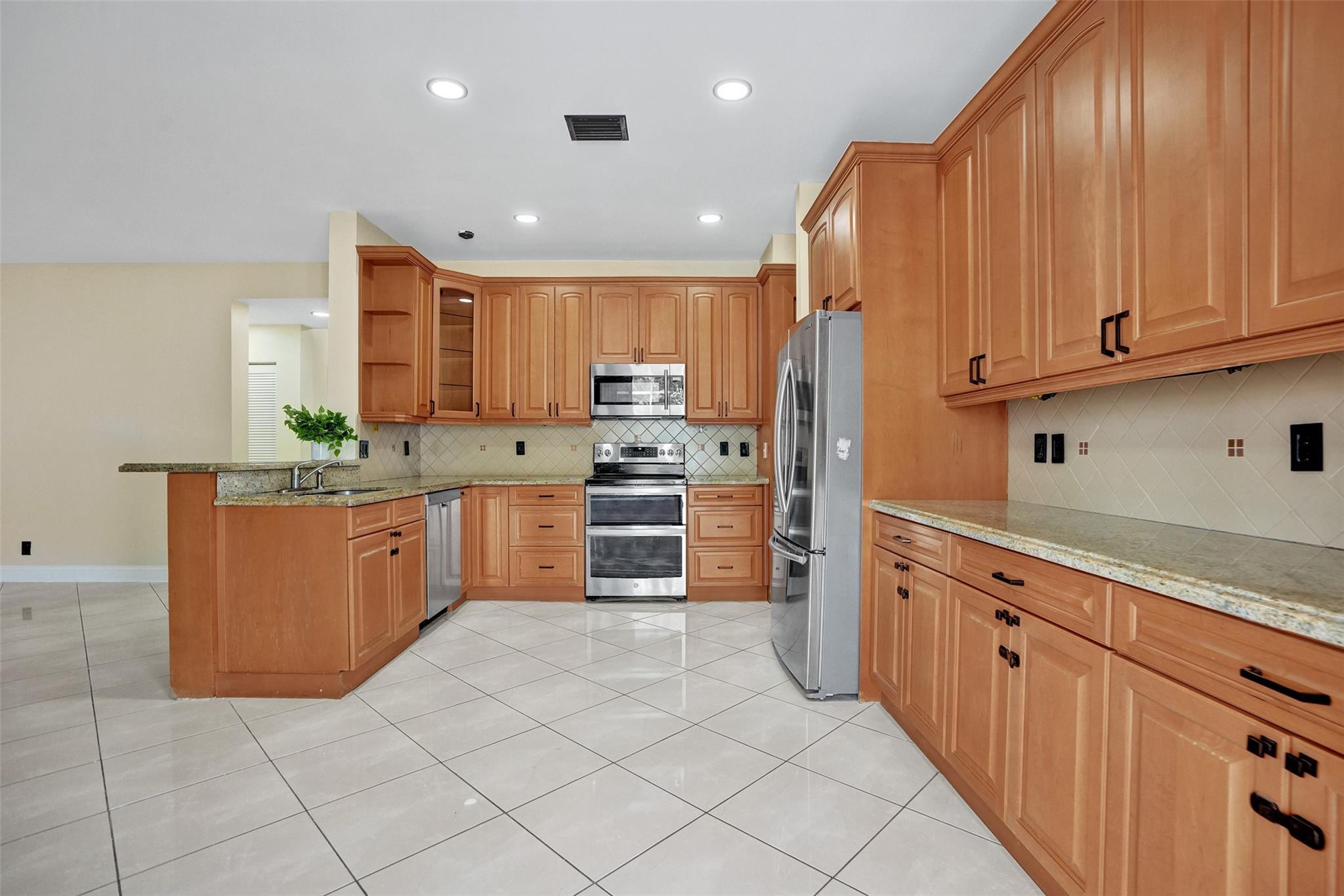574 Slippery Rock Road Weston, FL 33327 - Photo 17 of 64 a kitchen with stainless steel appliances granite countertop a stove a sink dishwasher and a refrigerator