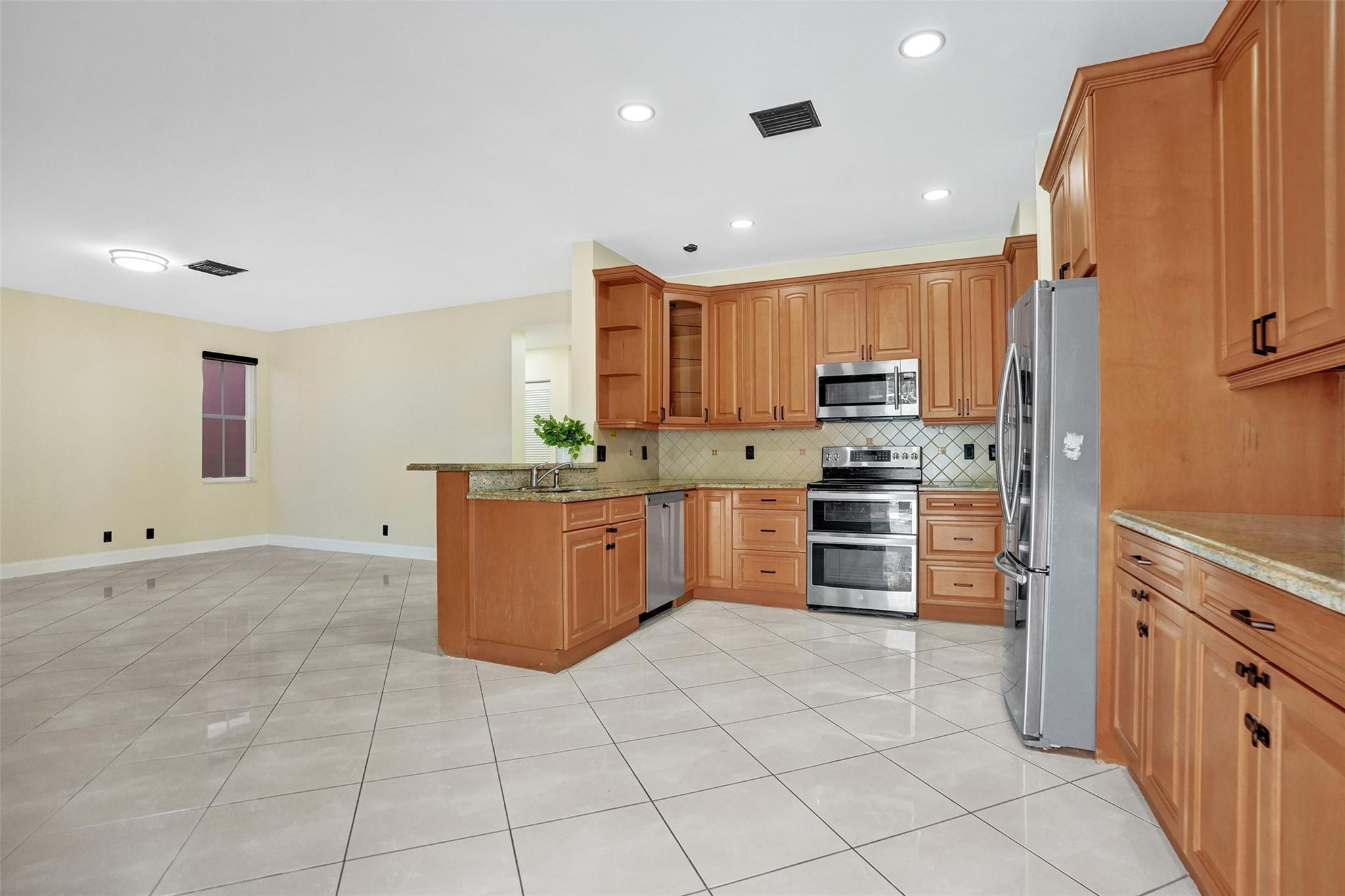 574 Slippery Rock Road Weston, FL 33327 - Photo 18 of 64 a kitchen with stainless steel appliances a stove a sink a microwave a counter top and oven
