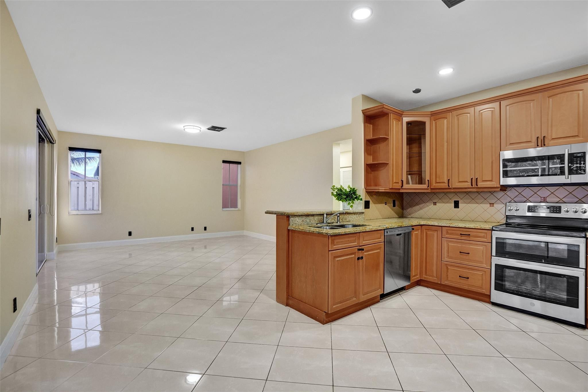 574 Slippery Rock Road Weston, FL 33327 - Photo 19 of 64 a large kitchen with stainless steel appliances granite countertop a stove and a sink