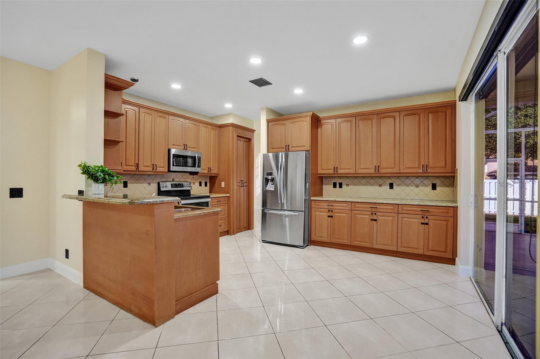 574 Slippery Rock Road Weston, FL 33327 - Photo 20 of 64 a kitchen with stainless steel appliances a refrigerator sink and cabinets