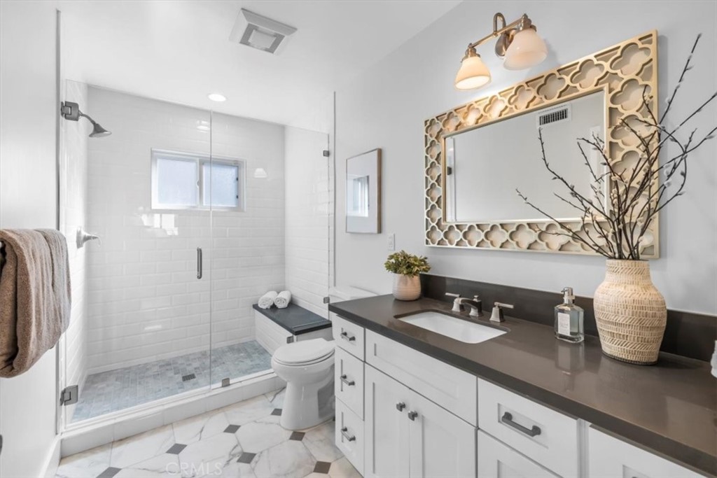 1416 11th Street Manhattan Beach, CA 90266 - Photo 13 of 28 a bathroom with a granite countertop sink a toilet a large mirror and shower