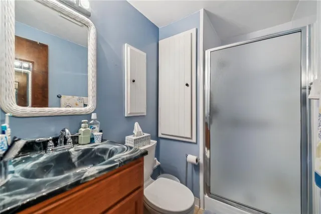 a bathroom with a granite countertop sink toilet and shower