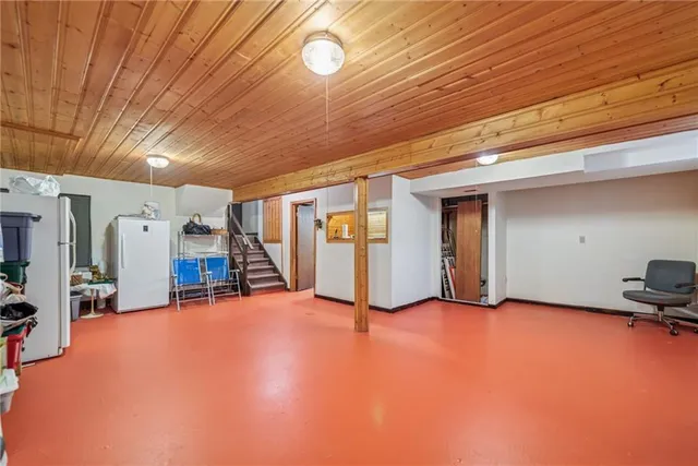 a view of an empty room with furniture and a window