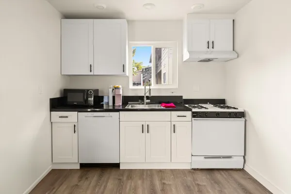 a kitchen with white cabinets and a sink