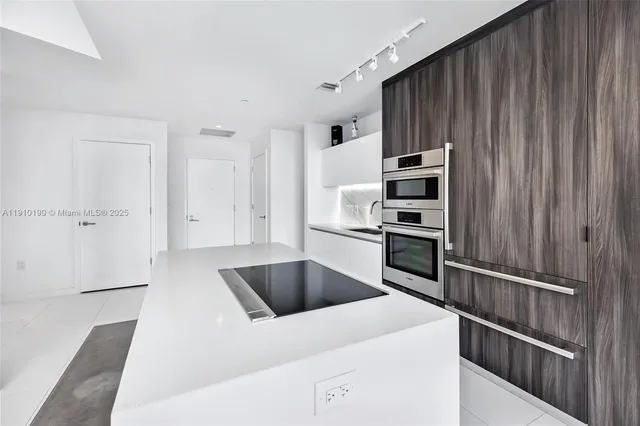 a kitchen with kitchen island a counter top space stainless steel appliances and cabinets