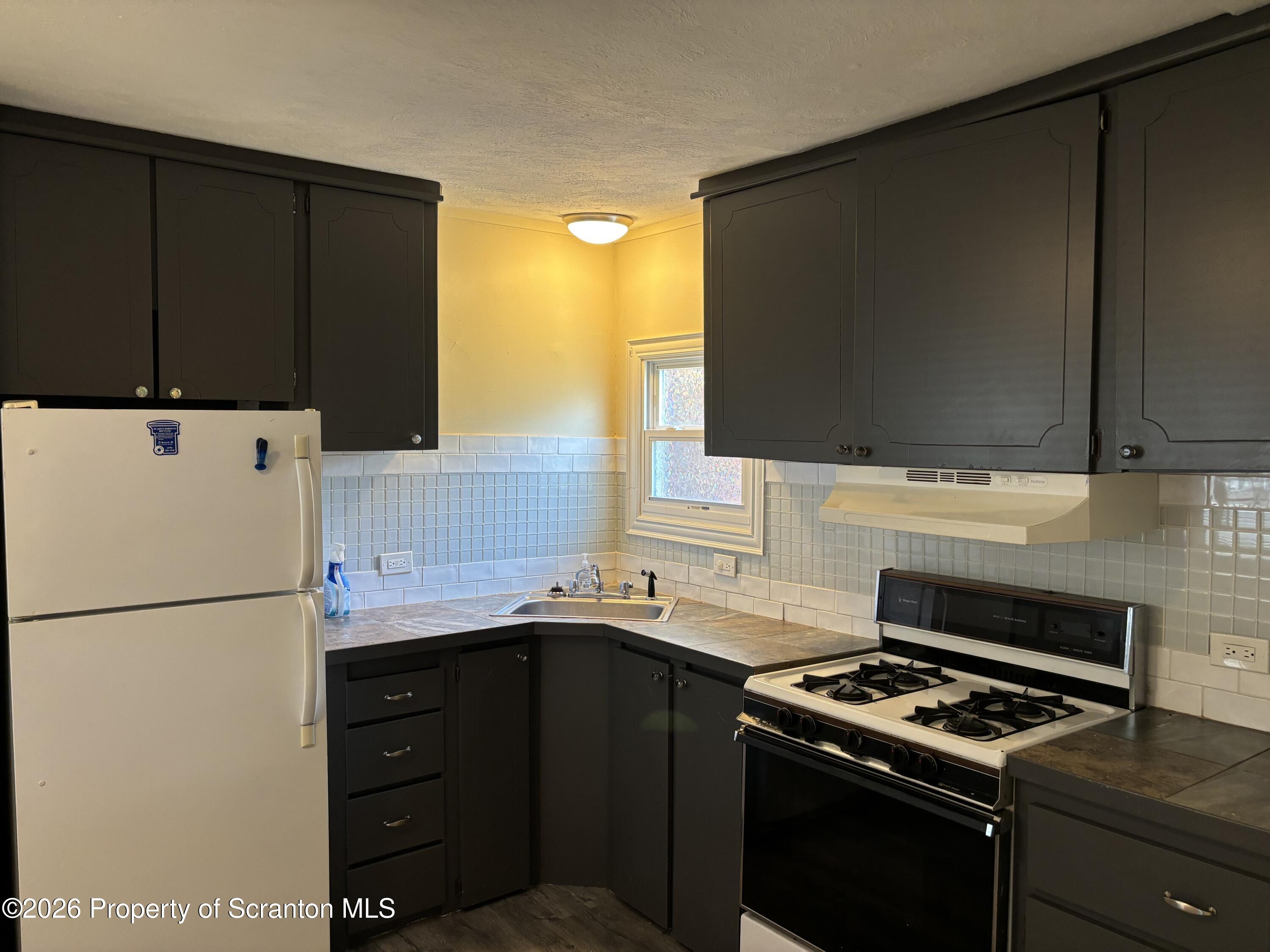 146 6th Street Blakely, PA 18447 - Photo 18 of 24 a kitchen with a sink a stove and a refrigerator