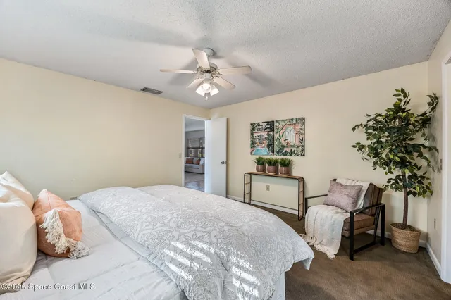 a spacious bedroom with a bed and a chandelier