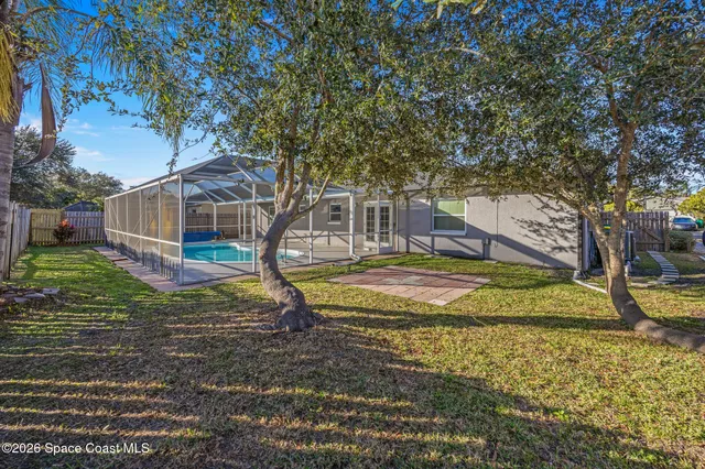 a view of a house with backyard and trees
