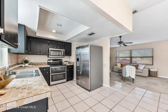 a kitchen with granite countertop a refrigerator and a stove top oven