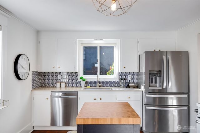 a kitchen with stainless steel appliances granite countertop a refrigerator a stove and a sink